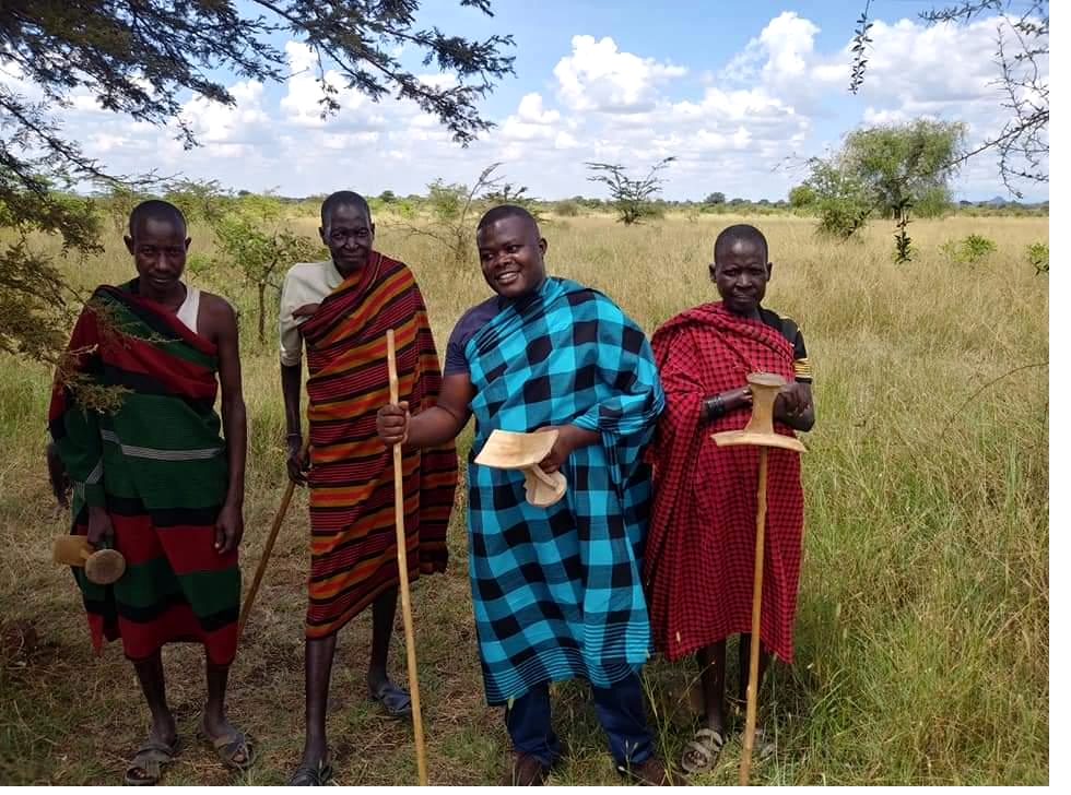 Pastoralist community members standing in open grassland in Amudat, Karamoja