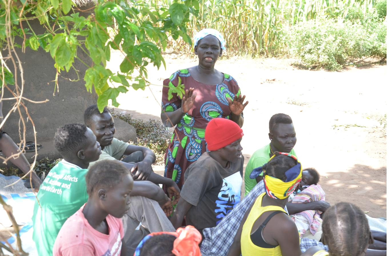 A focus group discussion in progress with community members seated in a circle outdoors