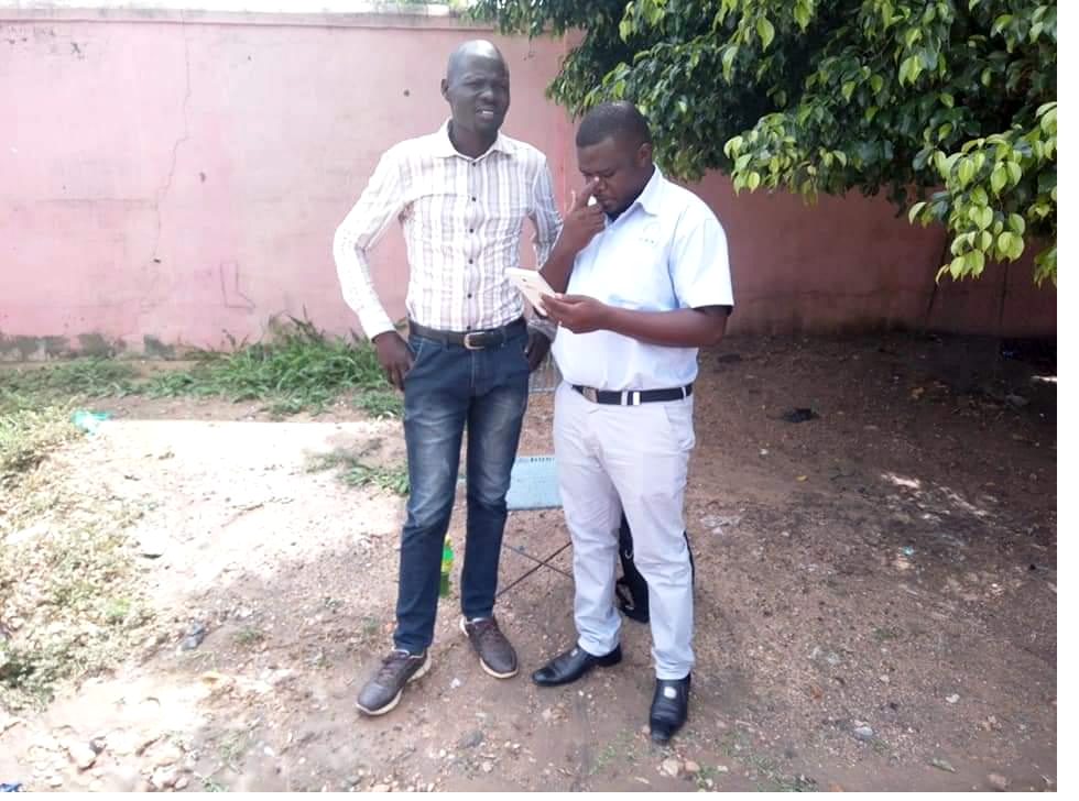 Field supervisors reviewing digital data capture on a mobile device at a payam in Juba, South Sudan